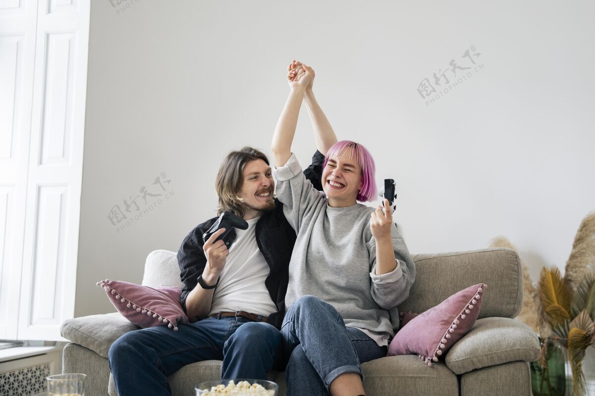 娱乐年轻夫妇在家玩电子游戏女人享受男人