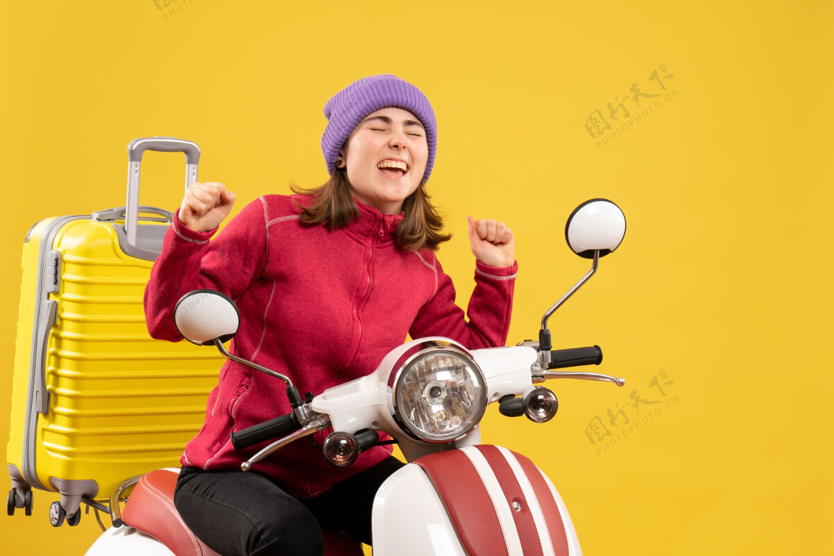 轻便摩托车正前方是一位穿着便服 骑着轻便摩托车 兴高采烈的年轻女子休闲男人坐着
