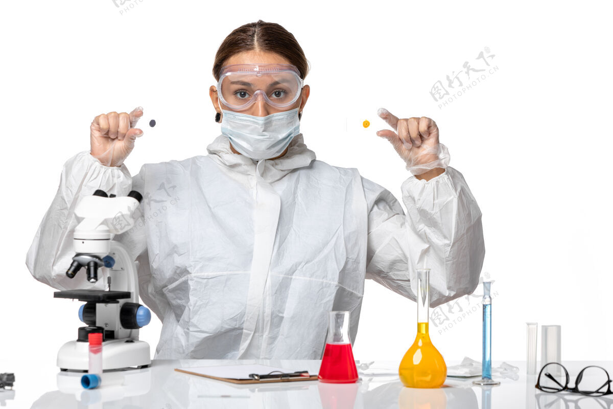 样品正面图女医生穿着防护服 戴着口罩 拿着白色背景的样本医学健康大流行病毒冠状病毒防护外套面罩