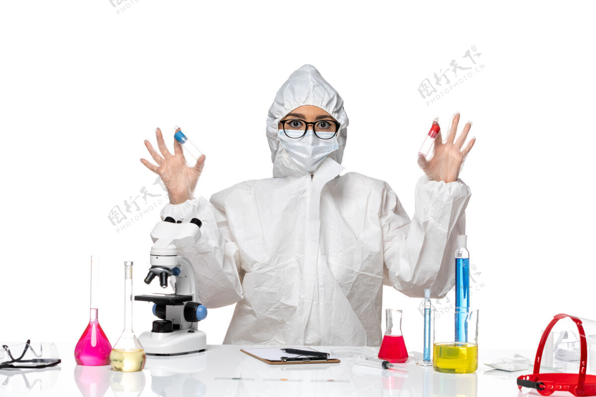 人正面图身着特殊防护服的女化学家拿着浅白色背景上的空烧瓶病毒健康化学冠状病毒持有健康视图