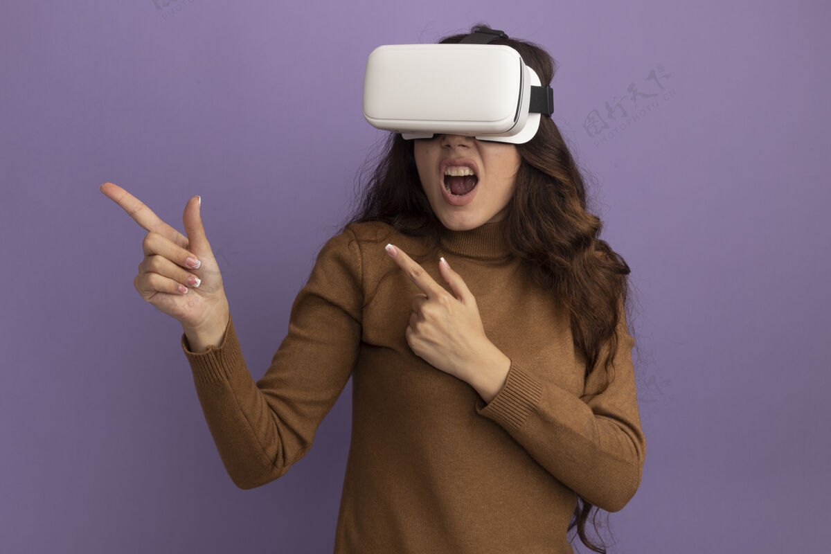 脸未发布的年轻漂亮女孩戴着虚拟现实耳机点在一边孤立的紫色墙壁与复制空间女孩姿势穿着