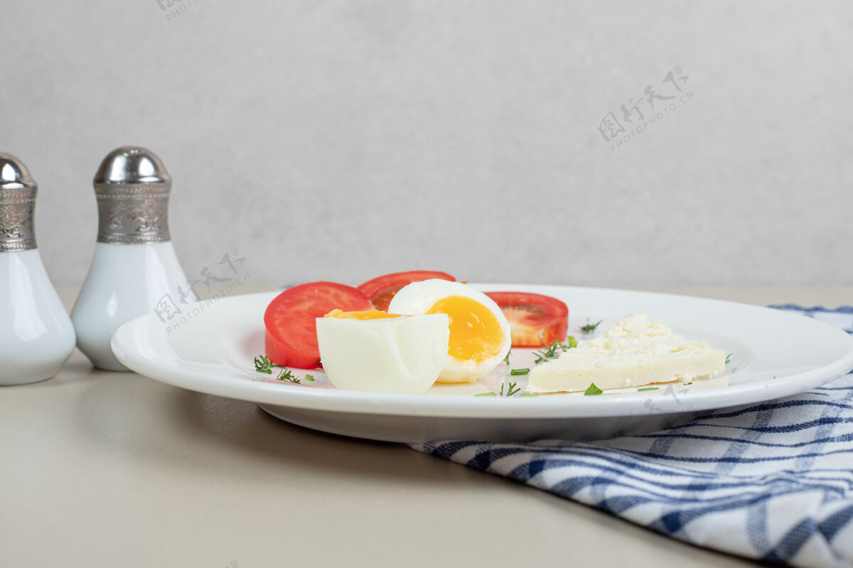 鸡蛋一盘白番茄片和煮鸡蛋桌布盐绿色