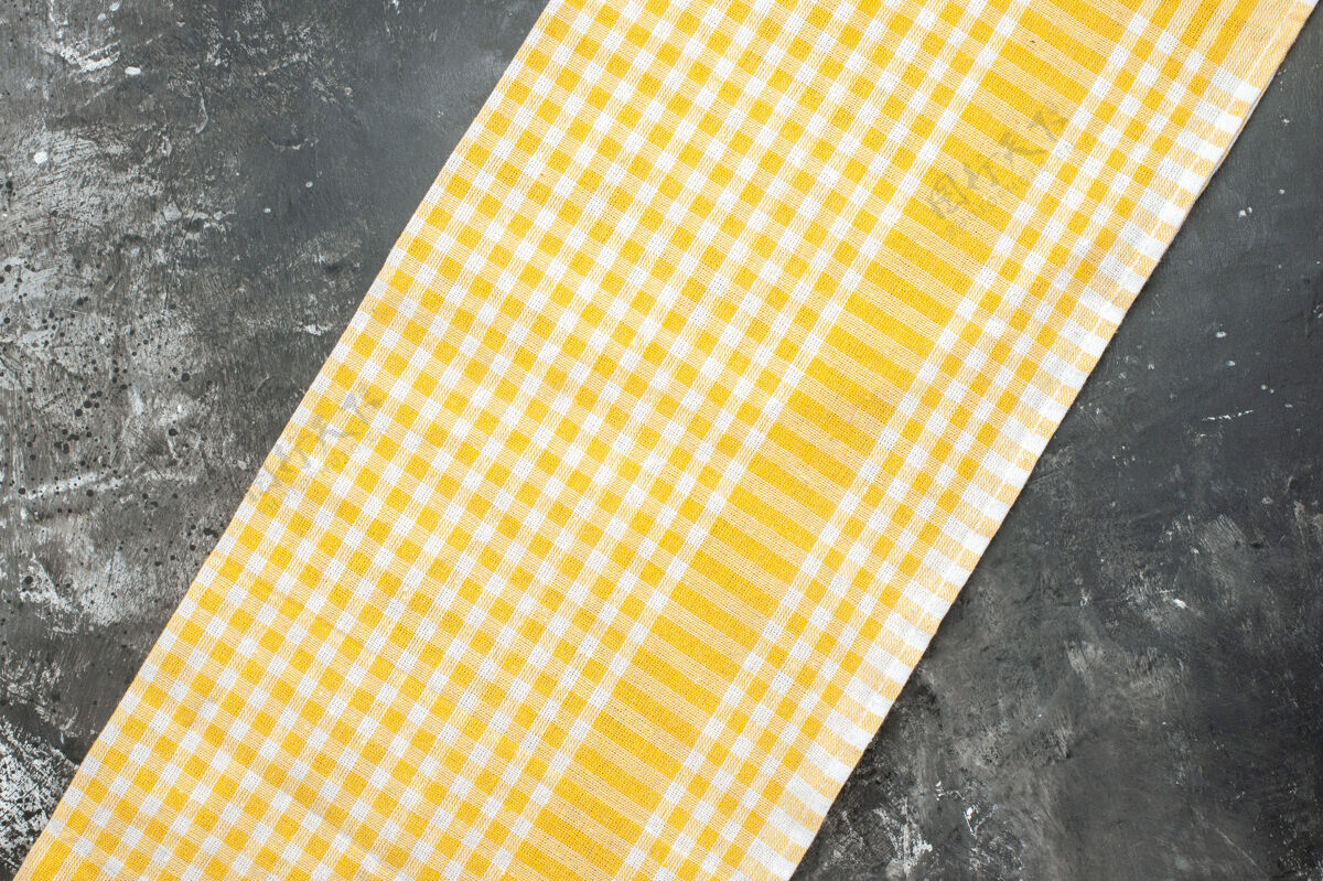 材料灰色表面上黄色毛巾的顶视图质地衣服布片