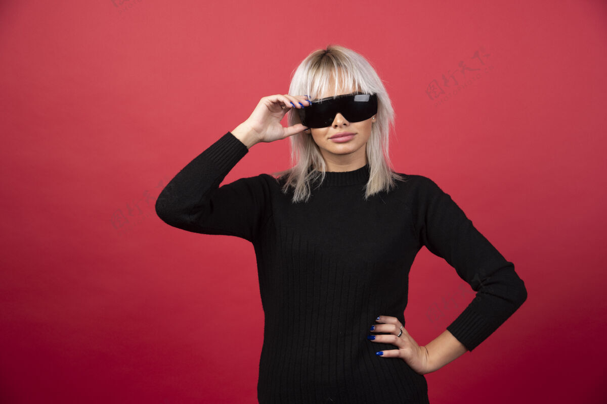 女人红墙上戴着黑眼镜的女人的画像成人姿势年轻