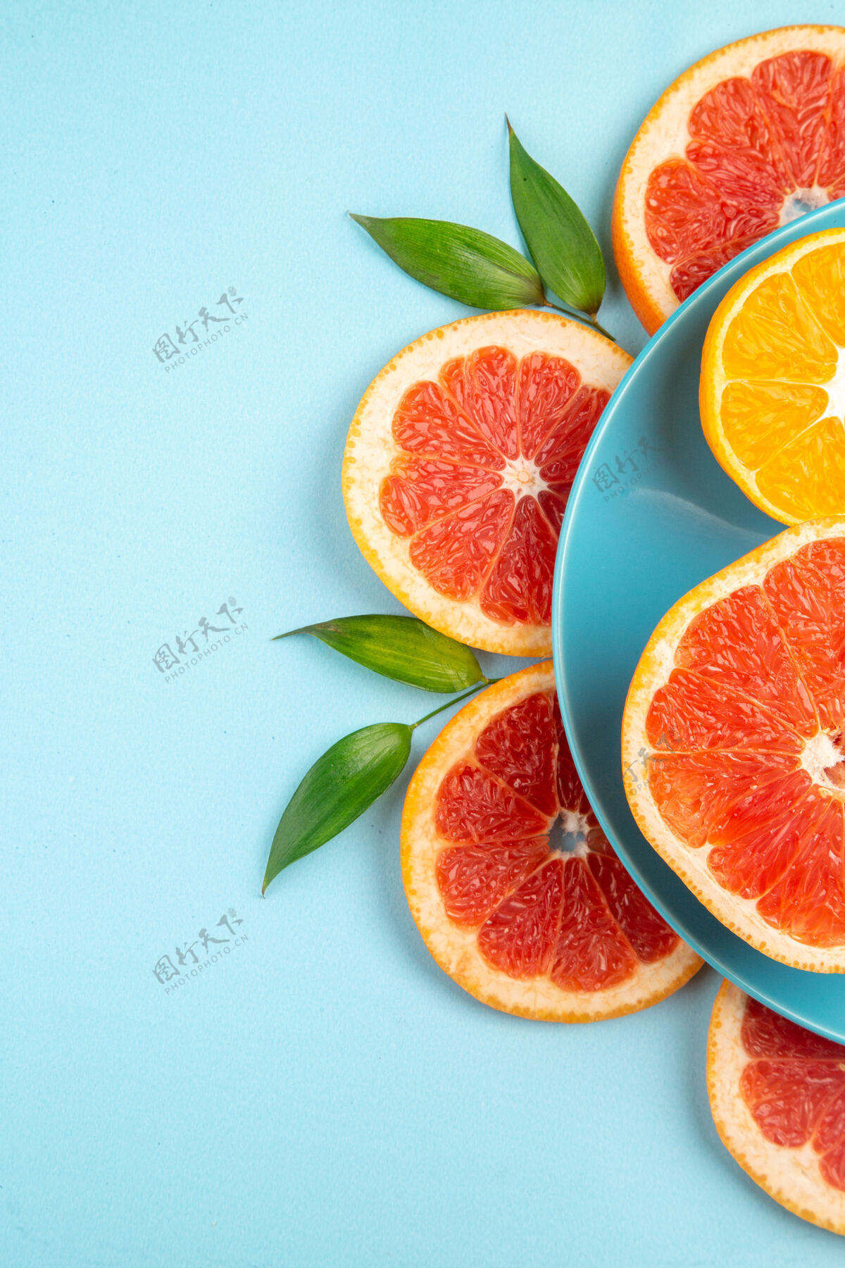 切片蓝色表面上美味的葡萄柚水果片俯视图柠檬柑橘健康
