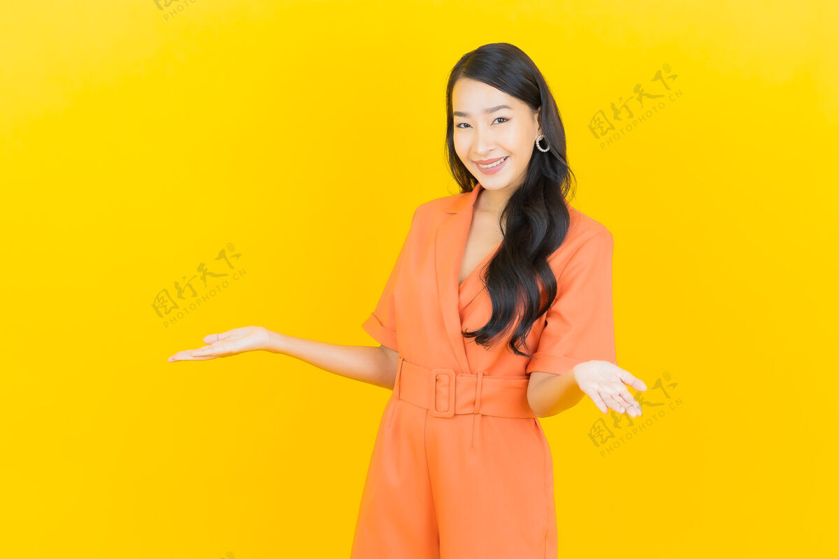 中国人肖像美丽的亚洲年轻女子微笑着行动黄色闪亮有趣卷发