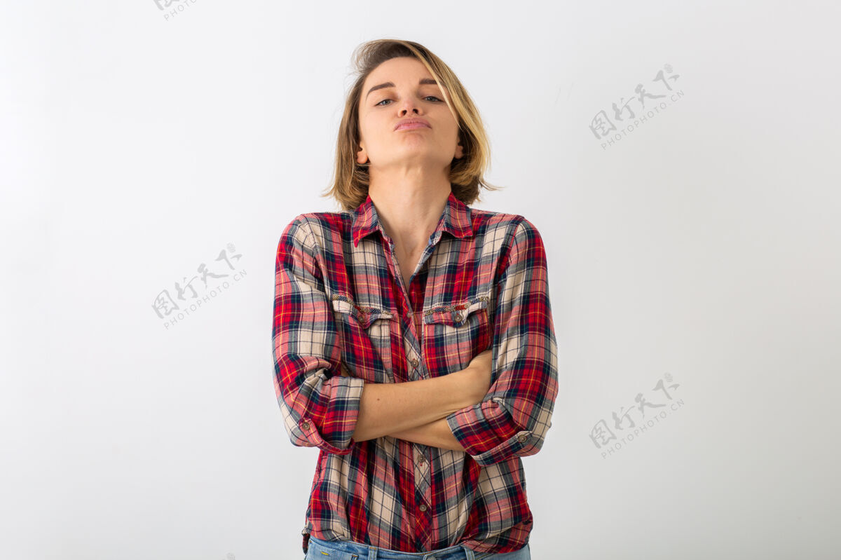 玩耍穿着格子衬衫的年轻有趣的情绪化女人在白色的工作室墙上摆出孤立的姿势 表现出愤怒的姿态表情表演肖像