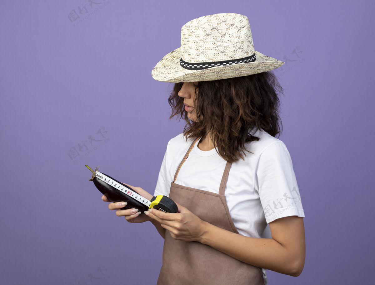 制服想着年轻的女园丁穿着制服戴着园艺帽用卷尺量茄子人成人紫色