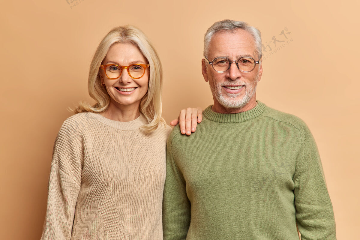 女人半身镜头的中年妇女和男子微笑愉快地穿套头衫和眼镜关系金发眼镜