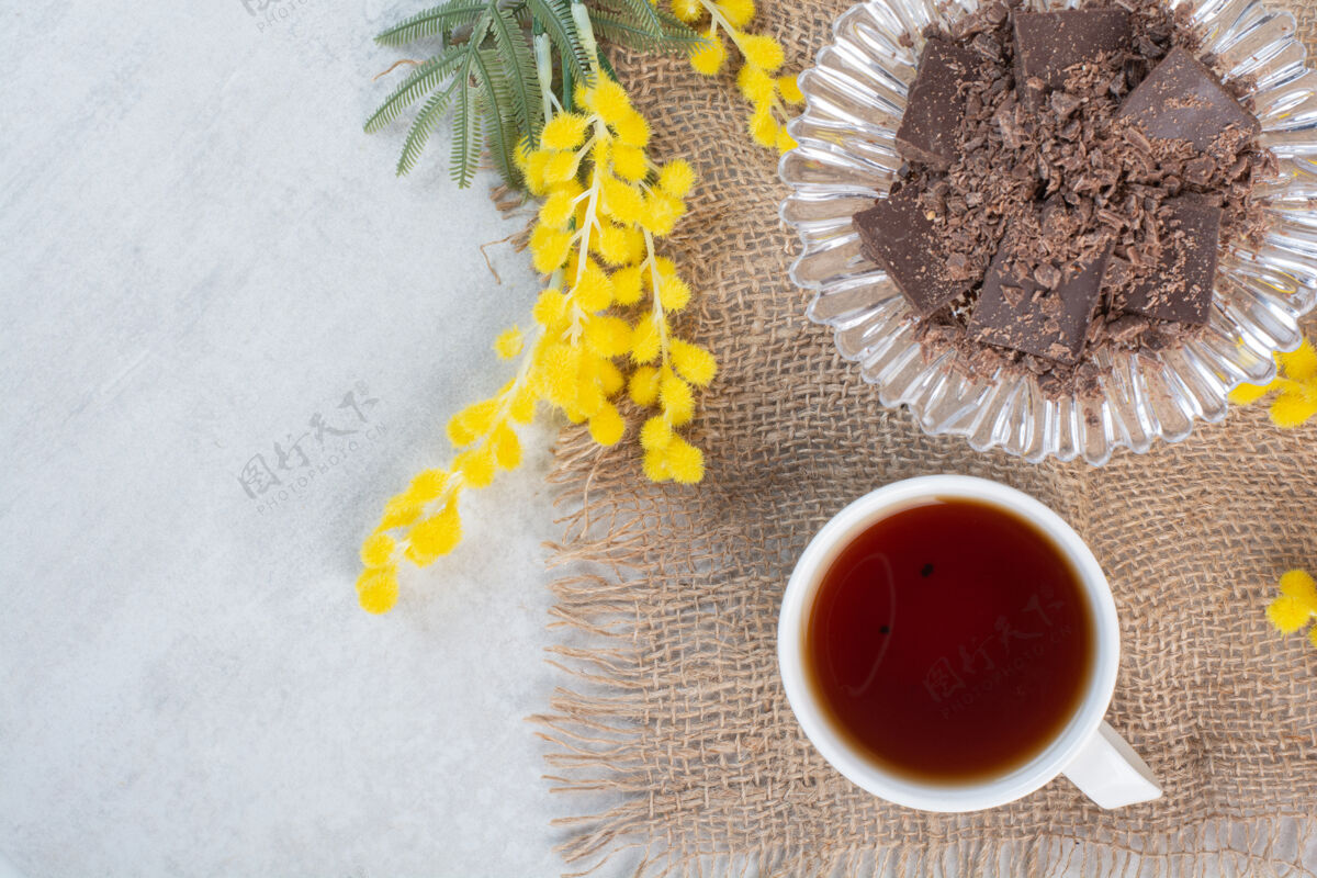 糖果一杯茶 一个放在粗麻布上的巧克力碗 上面放着鲜花好吃的茶碎的