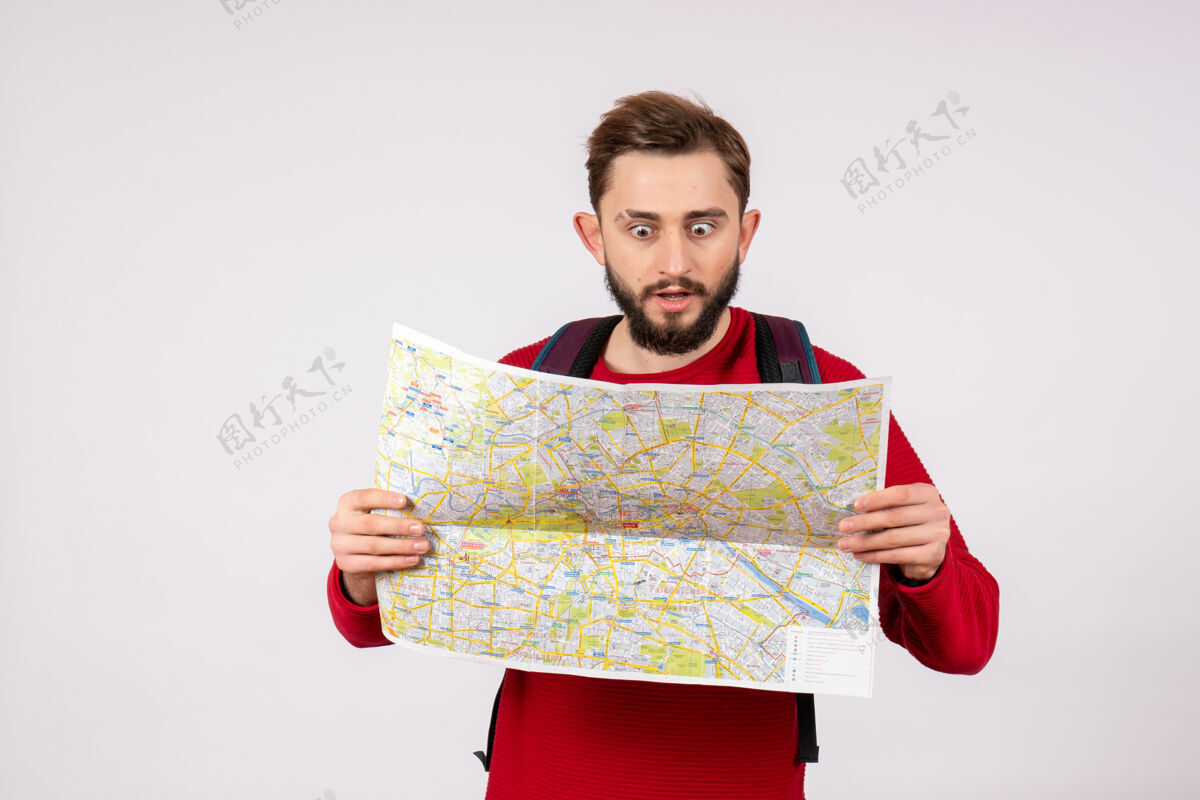 地图正面图年轻男性游客背着背包在白色墙壁上探索地图科维德飞机度假情感病毒飞行色彩视图探索情绪