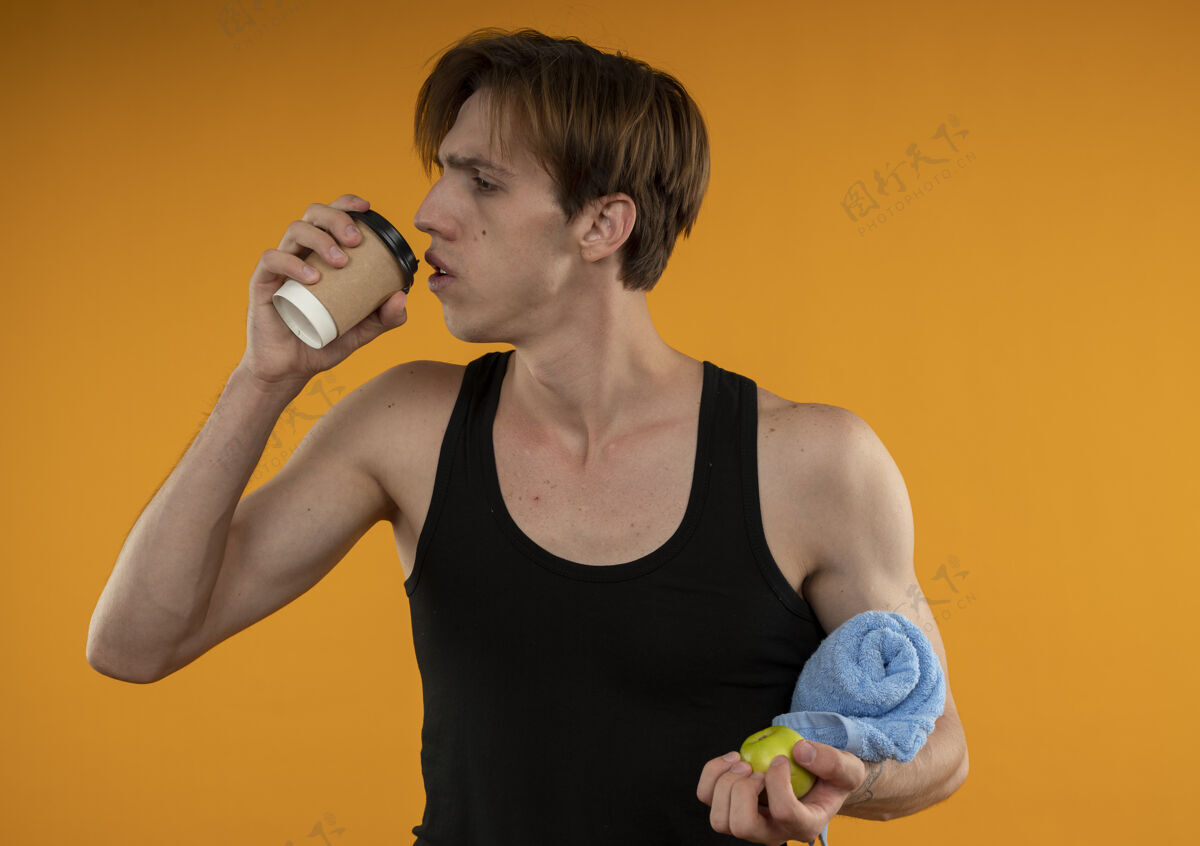 运动看着一边想着运动的年轻人拿着毛巾 喝着橘色墙上的咖啡思考侧身抱着