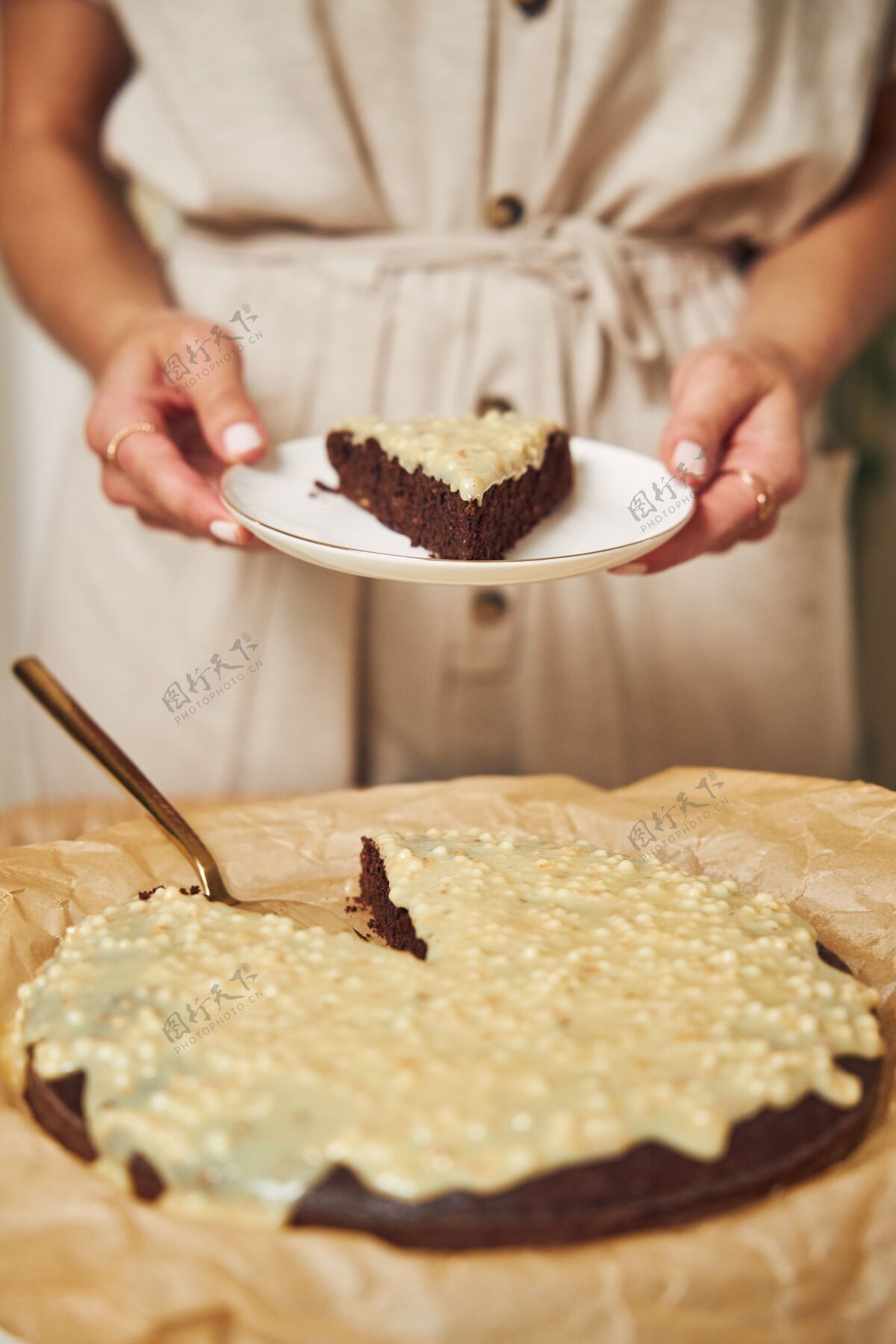 桌子年轻的女厨师在白色的桌子上做着美味的奶油巧克力蛋糕烘焙布丁糖果