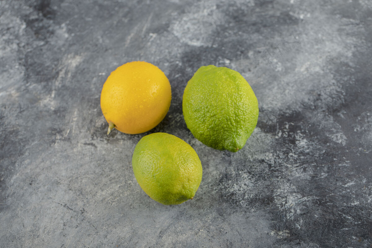 农业黄色和绿色的柠檬在大理石表面组成熟素食
