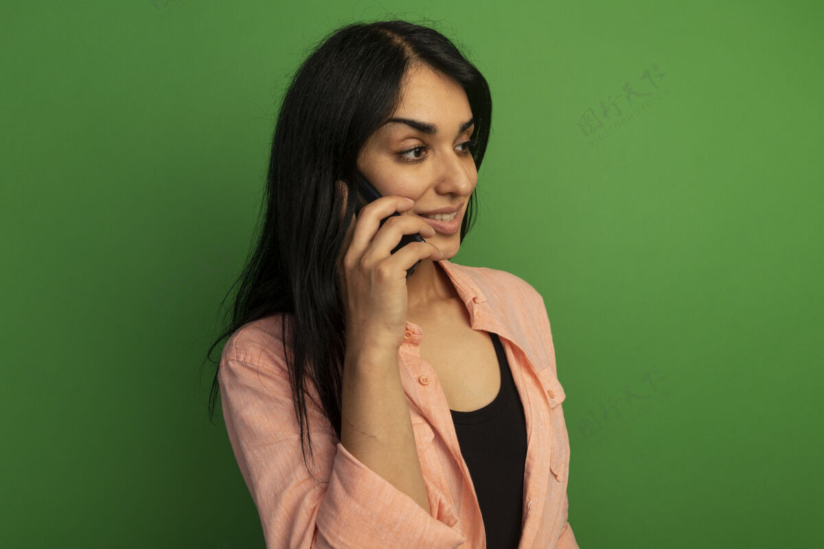 电话微笑着看着身边穿着粉色t恤的年轻漂亮女孩在电话里说绿色隔离说话粉色穿