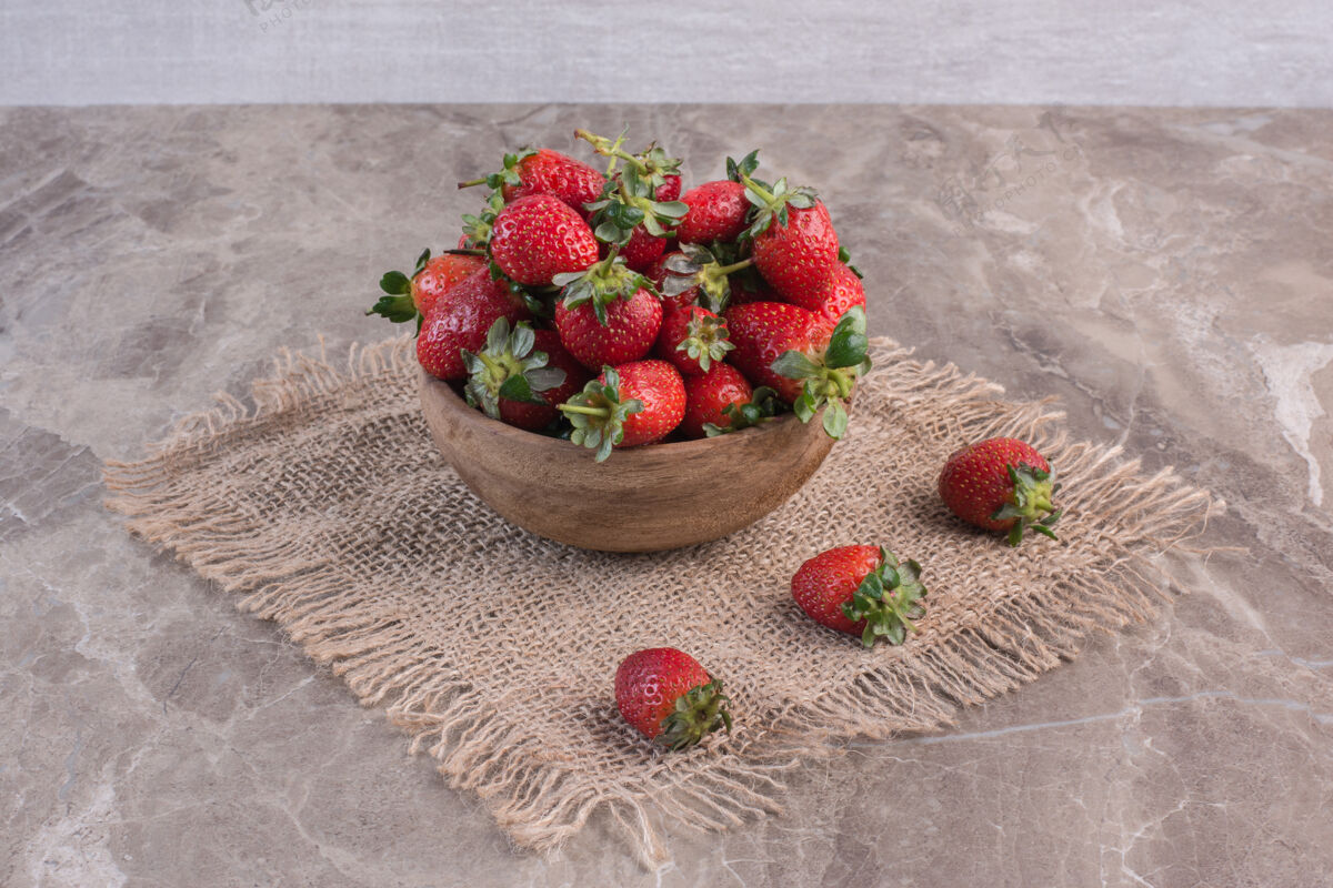 健康在大理石表面的一块布上放一碗草莓减肥多汁草莓