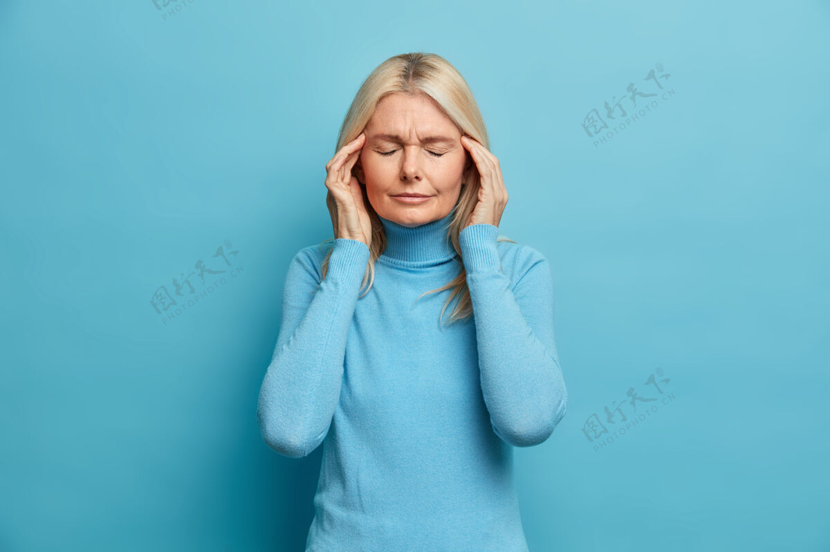 蓝色紧张的金发皱纹女人遭受可怕的头痛摸太阳穴感觉不舒服闭上眼睛显示疼痛偏头痛头疼痛