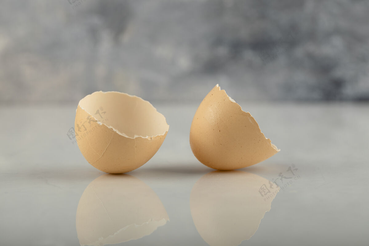 一半在大理石表面上打碎的棕色蛋壳鸡崩溃自然