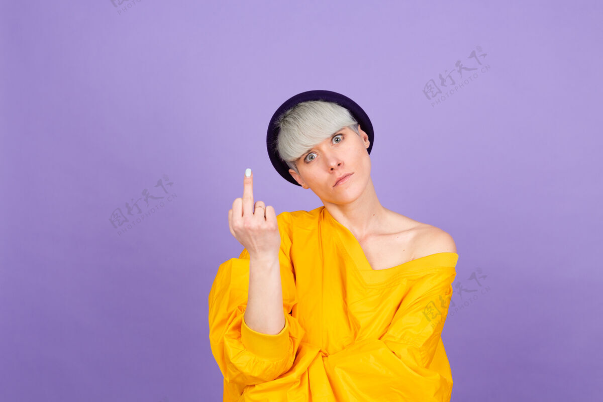 人紫色墙上的时髦欧洲女人愤怒嘴唇时尚