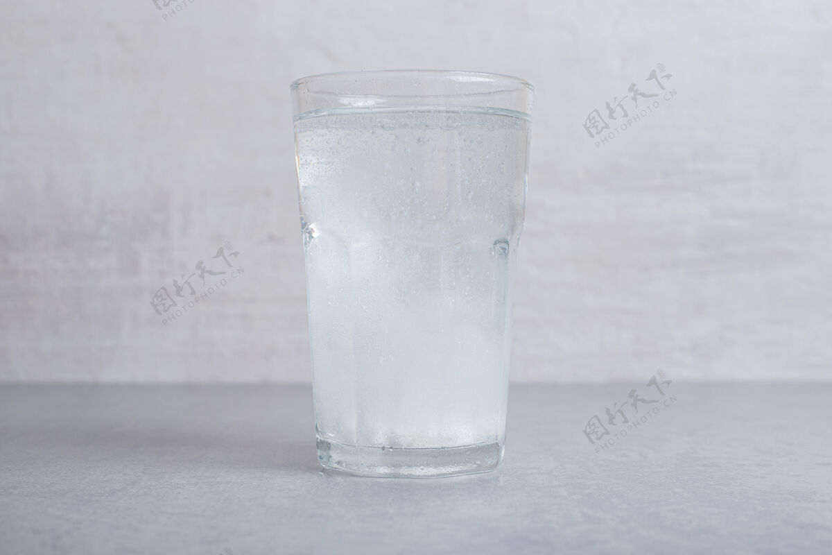 玻璃一杯纯正的冷水 背景是灰色的冷液体滴