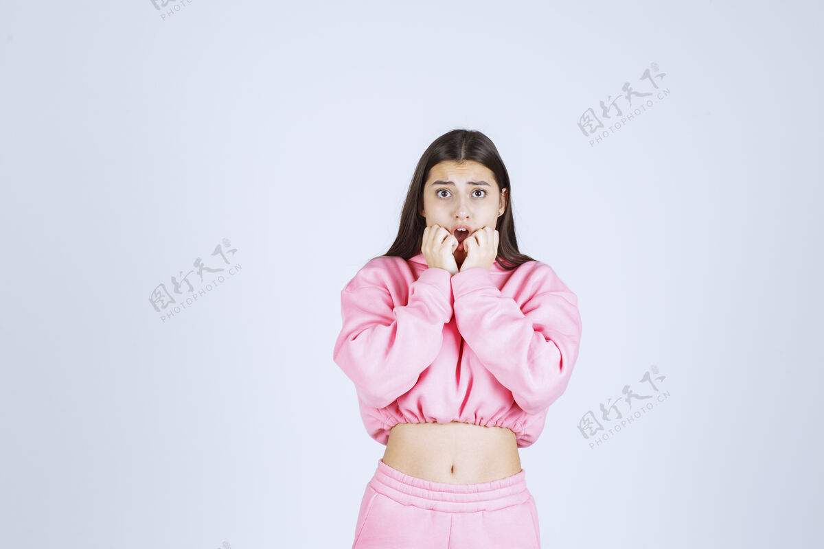 装束穿着粉色睡衣的女孩看起来又害怕又害怕成人激动人类