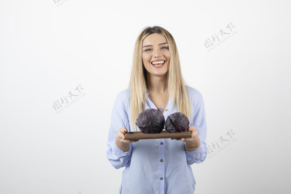 人一个微笑的美女模特站着拿着卷心菜模特漂亮食物