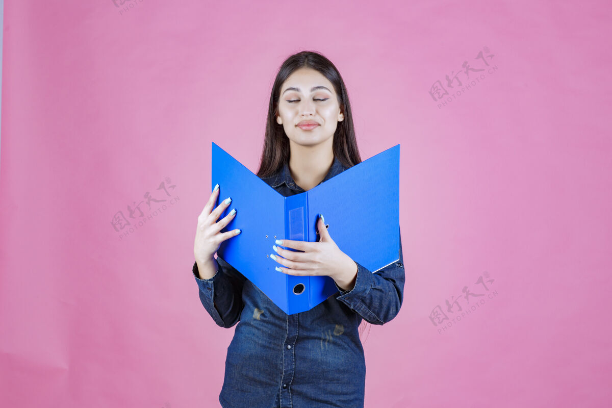休闲女商人拿着一个蓝色的文件夹自信装备助理报告