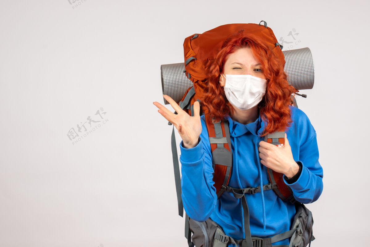 肖像正面图戴面具的女游客带着她的背包漂亮背包微笑