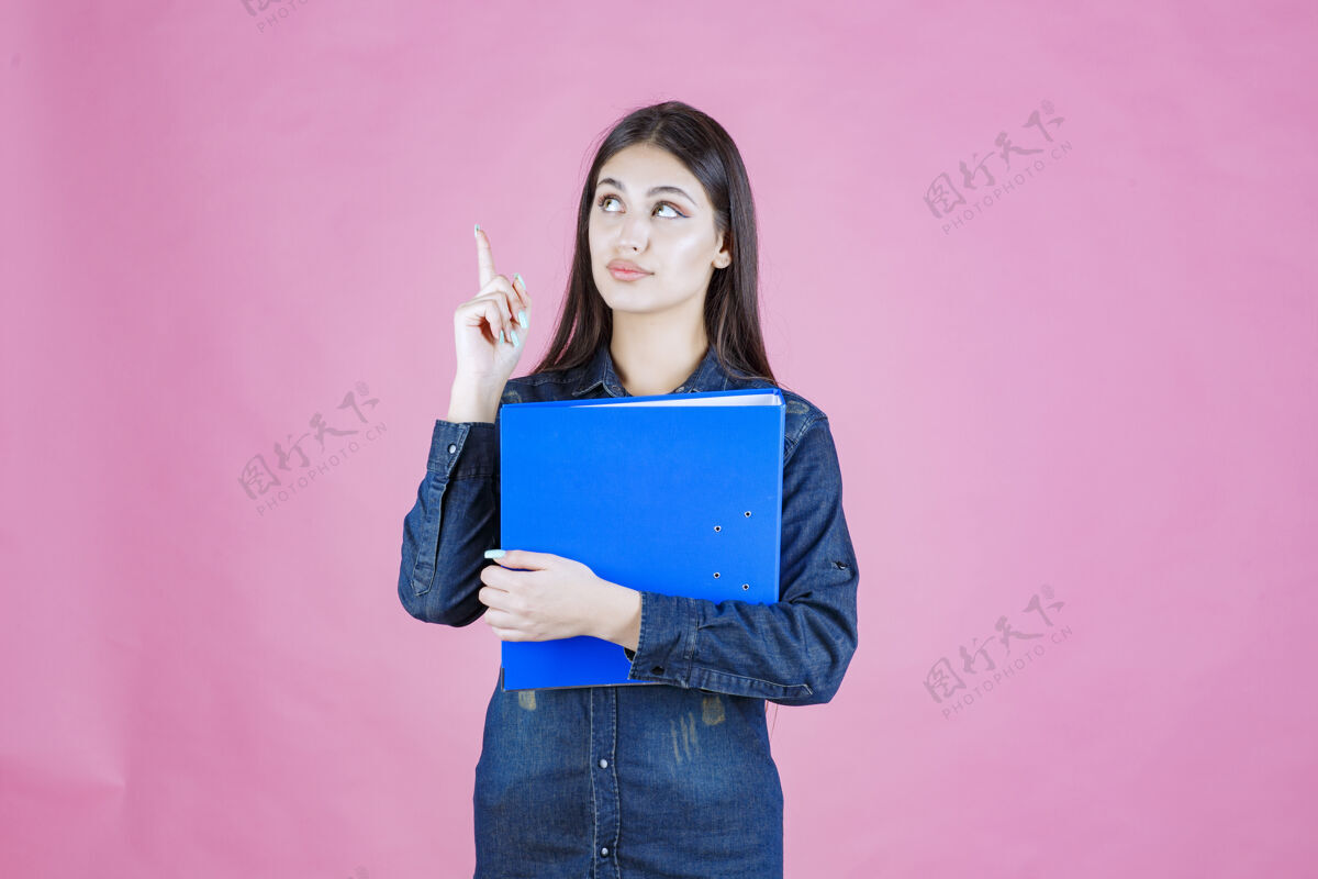 项目女商人拿着一个蓝色的报告夹 指着上面女性休闲助理