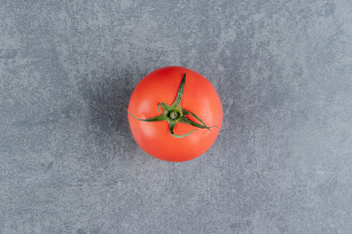 食物一个新鲜的红色番茄放在大理石表面好吃的西红柿蔬菜