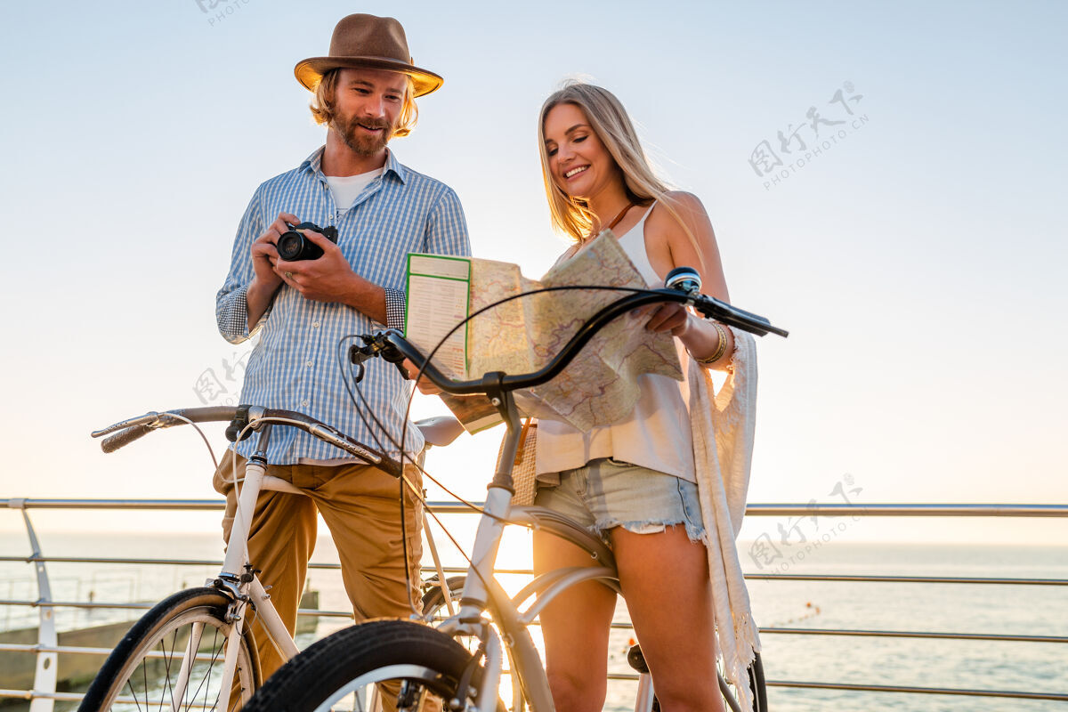 自行车年轻帅气的男女骑自行车旅游 手握地图 时髦的装束 朋友们一起玩乐 观光拍照自行车阳光浪漫