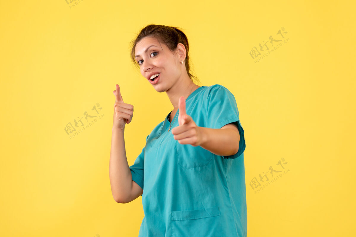 正面前视图黄色背景上穿着医用衬衫的女医生视图人衬衫