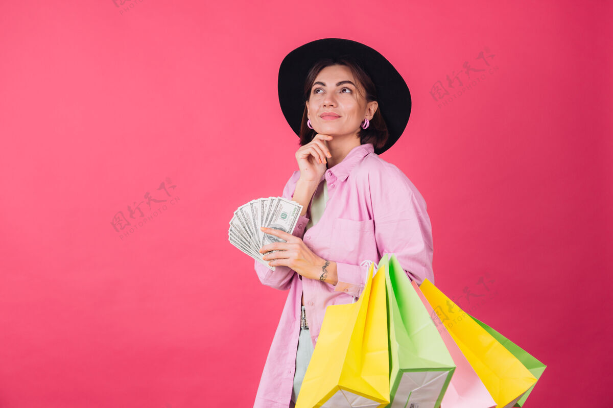 魅力红粉墙上戴帽子的时髦女人时尚美元银行