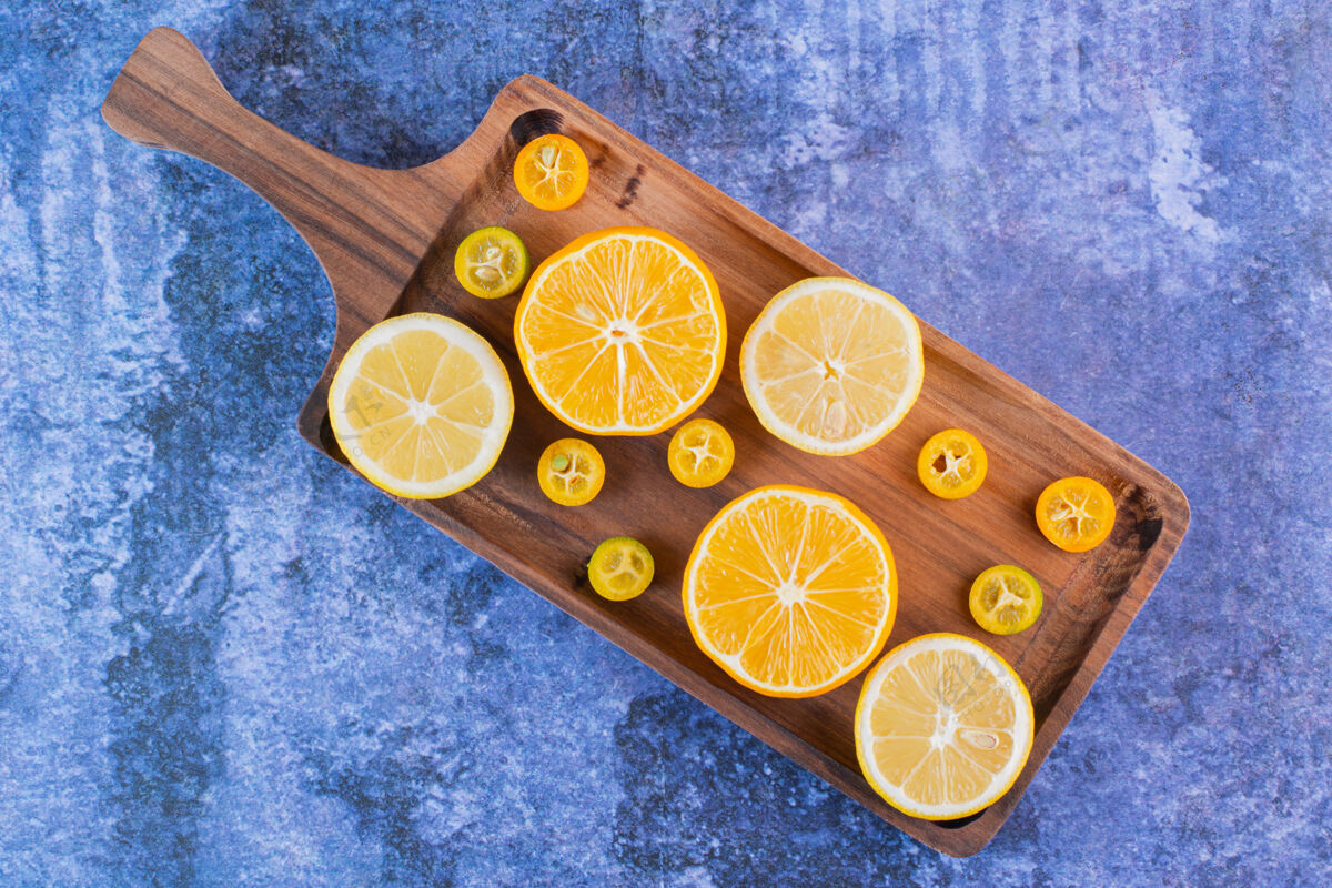 柑橘一堆柠檬和金橘片放在木托盘上变化混合有机