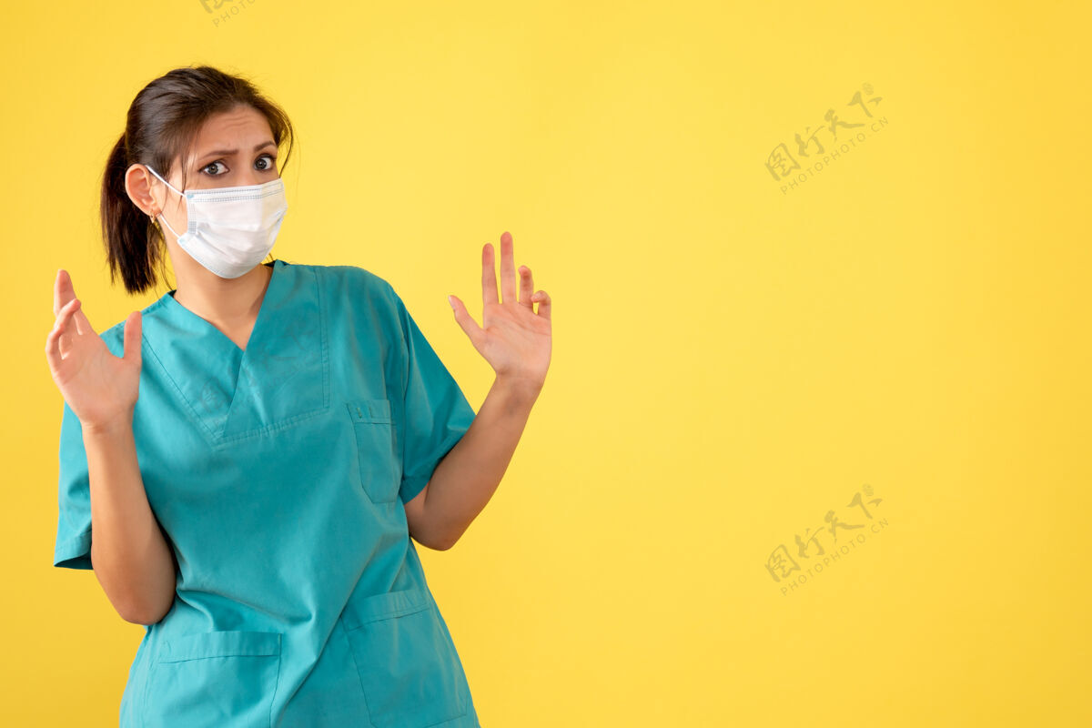 医疗前视图黄色背景上穿着医用衬衫和面罩的女医生一病毒面具