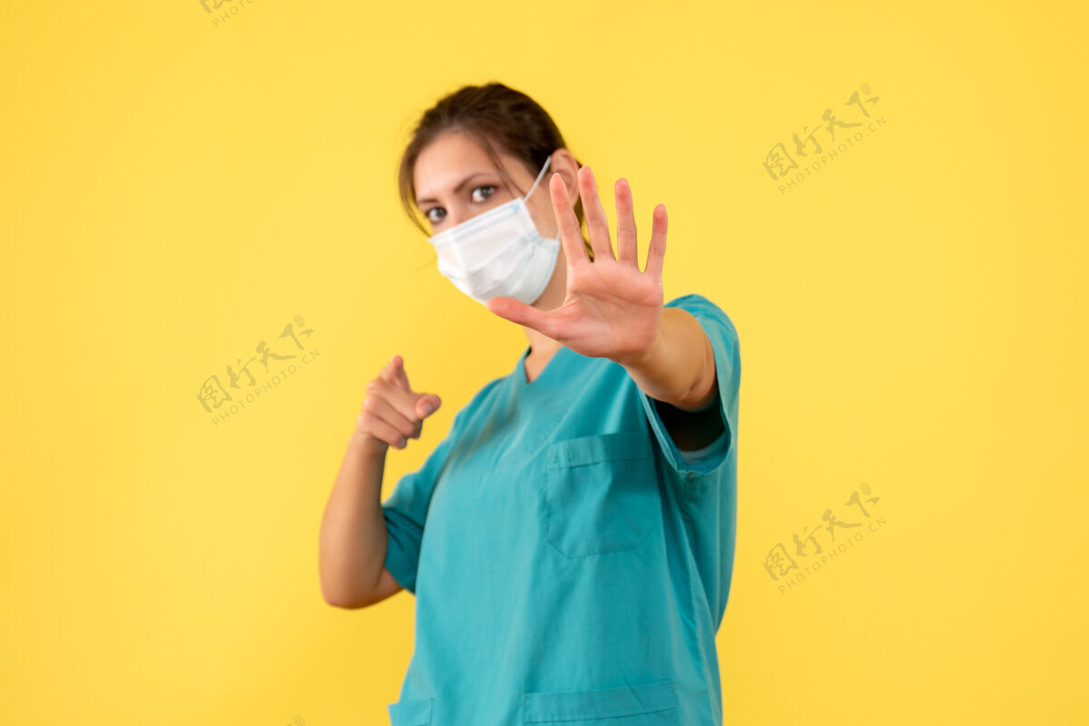 黄色前视图黄色背景上穿着医用衬衫和面罩的女医生女医生衬衫成人