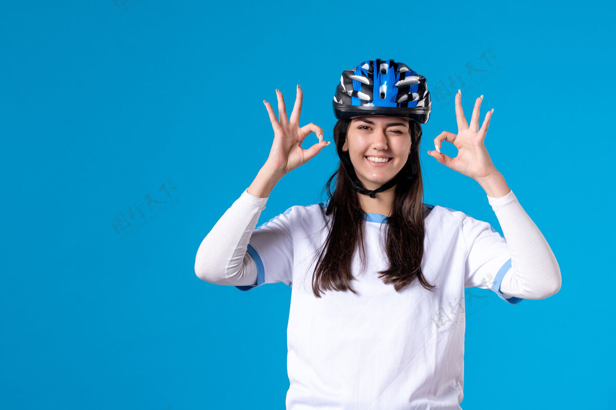 人前视图穿着运动服的年轻女性 蓝色墙上戴着头盔天空欢乐微笑