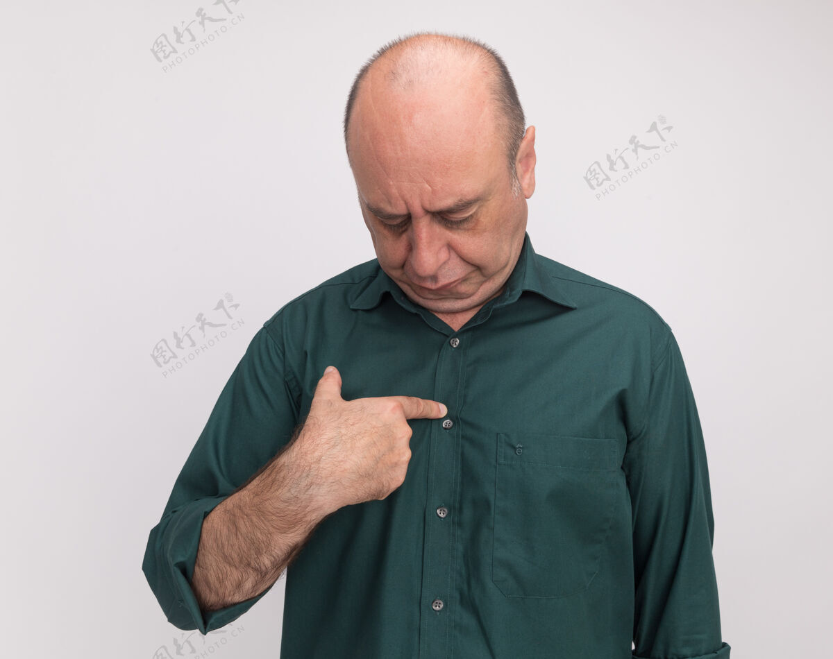 T恤戴着绿色t恤的低头中年男子把手指孤立在白墙上男人低腰穿