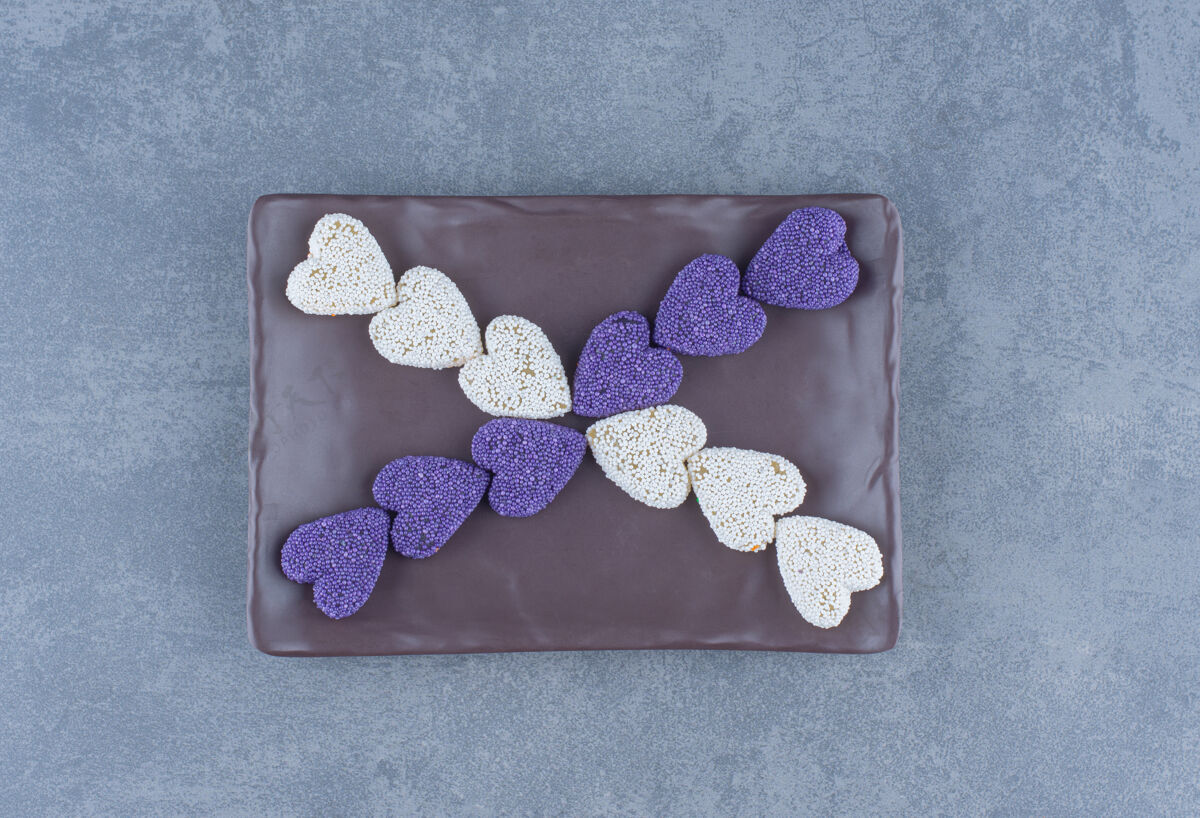 风味紫色和白色的饼干在黑板上 在大理石背景上美味美味五颜六色