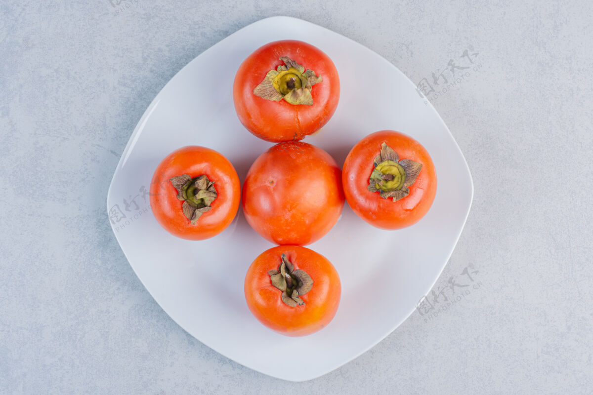 套餐成熟的橙色柿子水果特写照片白色盘子上的新鲜柿子食物自然特写