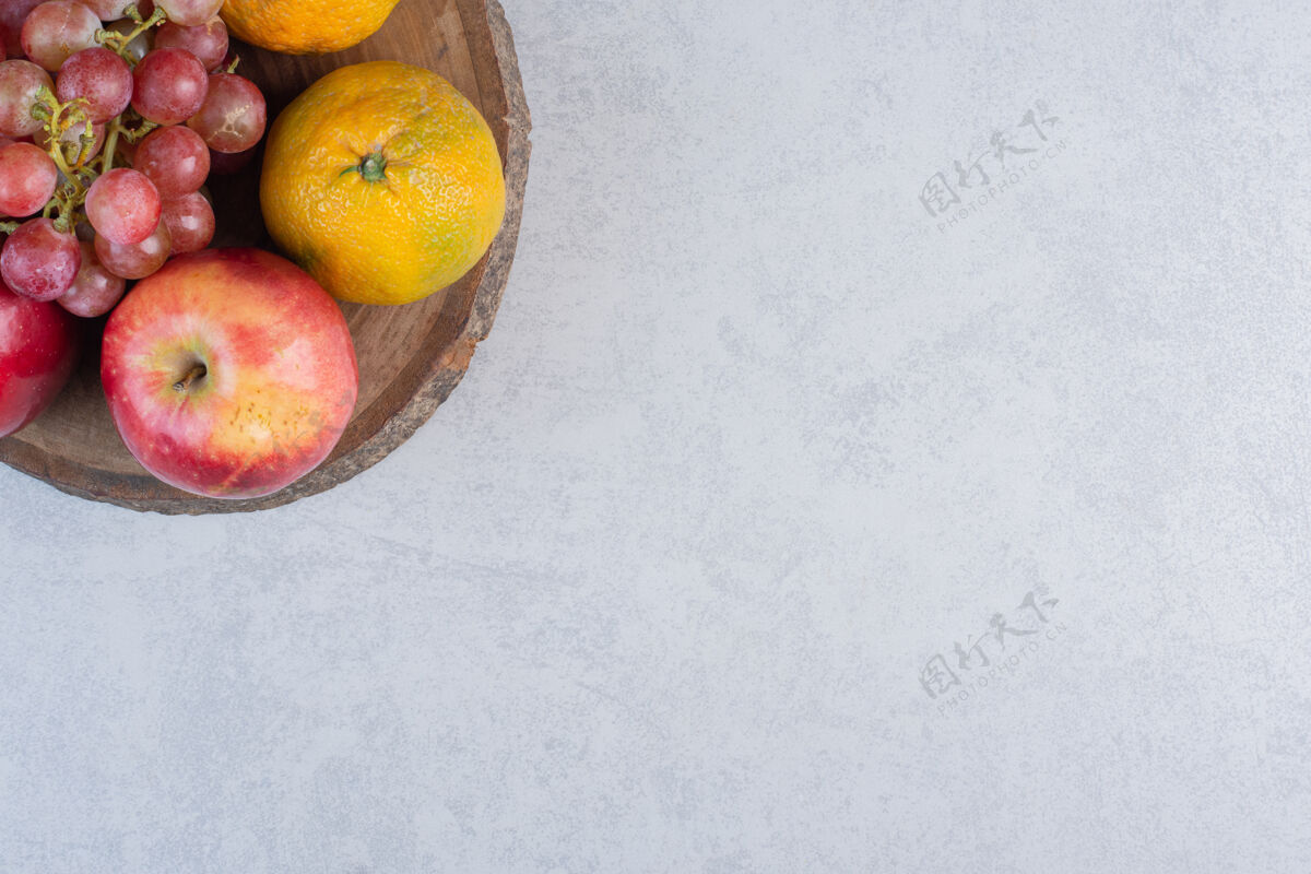 自然新鲜时令水果苹果葡萄和橘子放在木板上新鲜水果多种