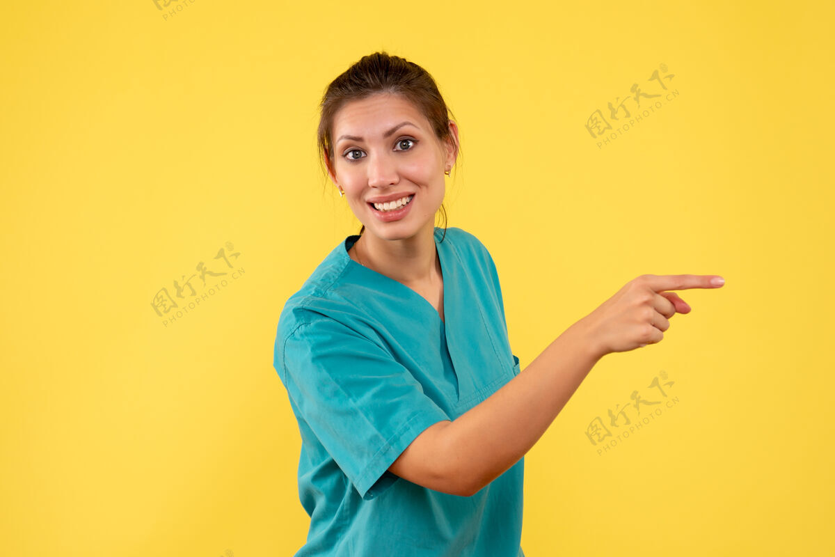 视图前视图黄色背景上穿着医用衬衫的女医生人黄色肖像