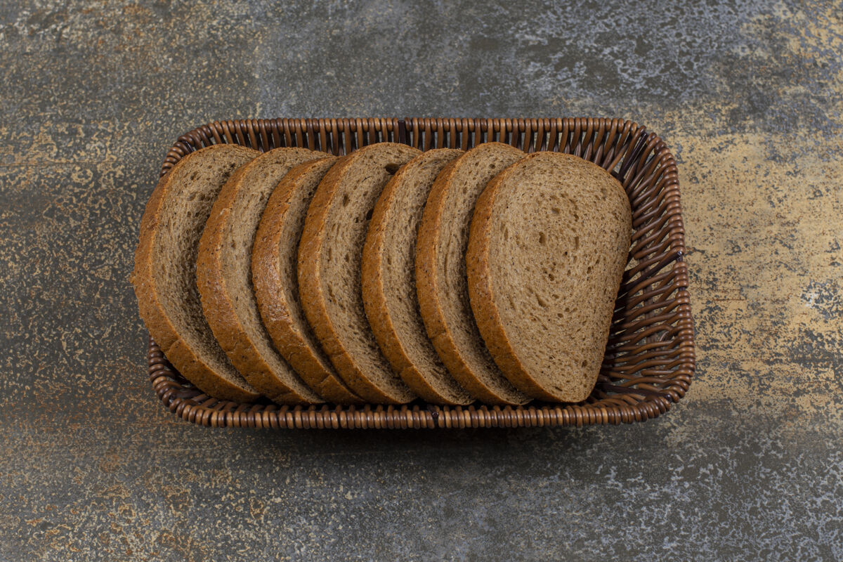 面包皮木篮里的新鲜黑麦面包片黑麦食物早餐