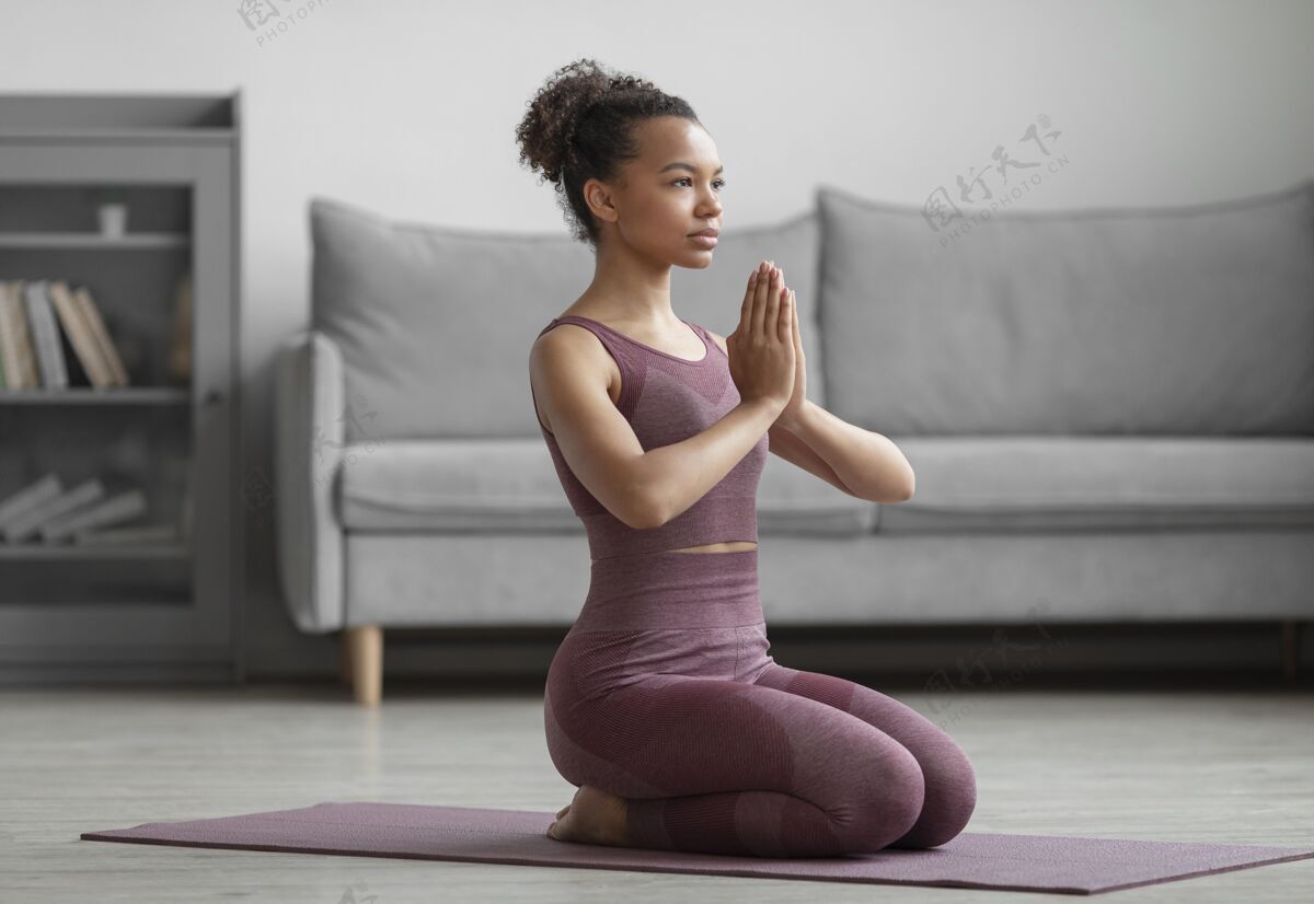 生活方式健身女士在家里用瑜伽垫做瑜伽内心的和平身体和平