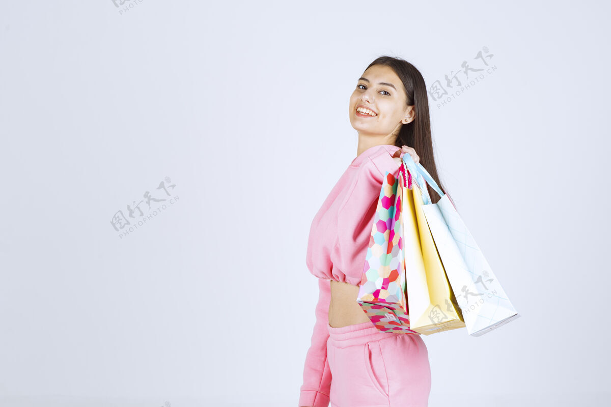 模特女孩把五颜六色的购物袋背在肩上微笑女性工人