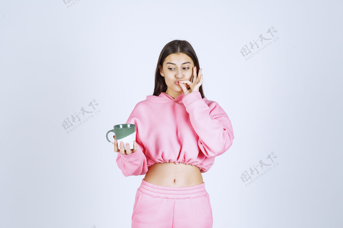 女性穿着粉色睡衣的女孩拿着咖啡杯 享受着咖啡的味道促销姿势雇员