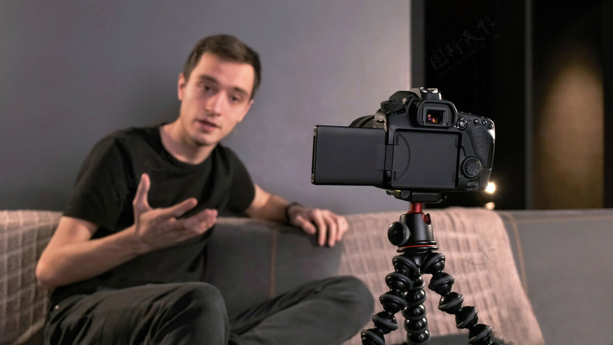 屏幕年轻的内容创作者用三脚架上的相机拍摄自己的照片工作男性媒体