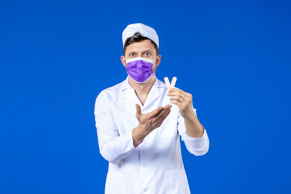 贴片前视图中的男医生穿着医疗服和面具举行小医疗补丁蓝色疫苗实验服病毒