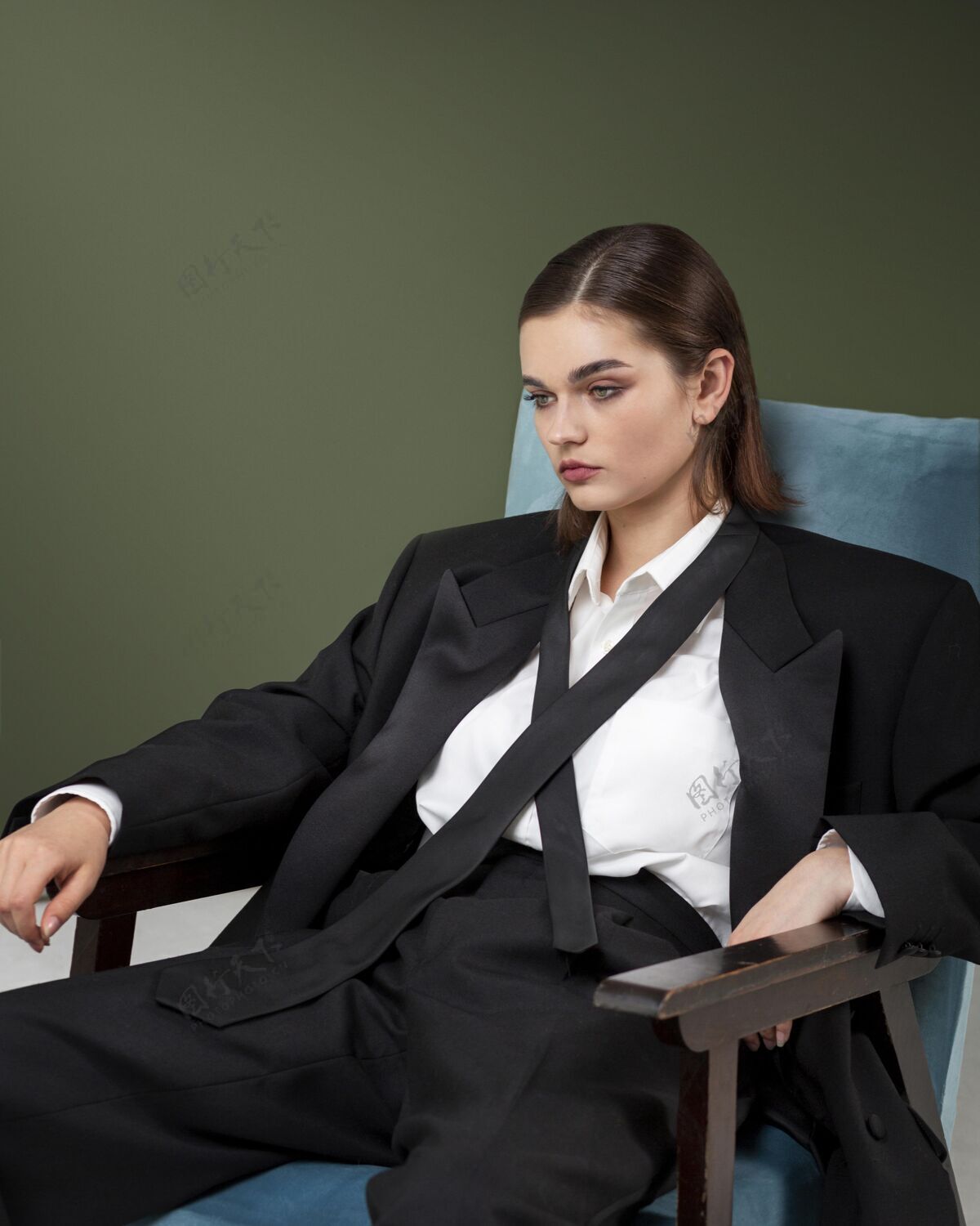 美丽优雅的女模特穿着夹克套装坐在扶手椅上全新的女性概念时尚魅力新女性