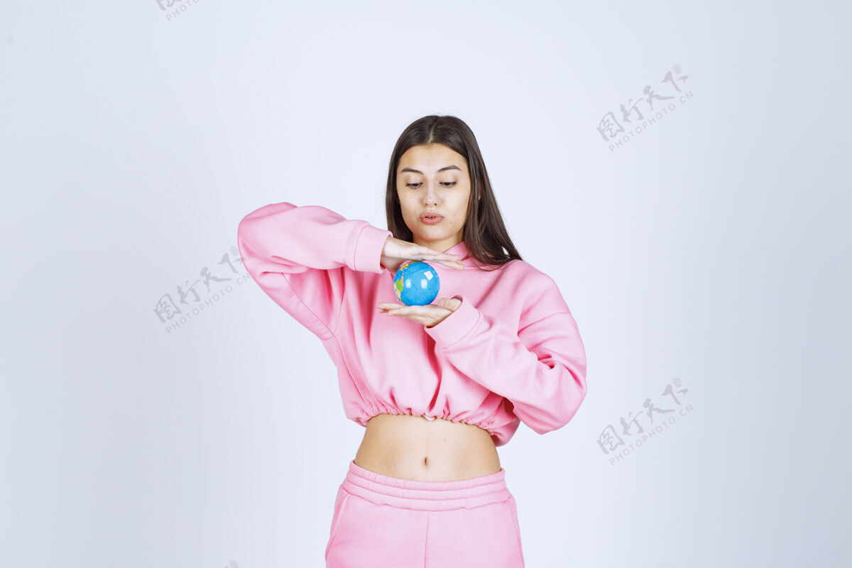 工作人员穿着粉色睡衣的女孩手里拿着一个迷你地球仪人体模型人类年轻